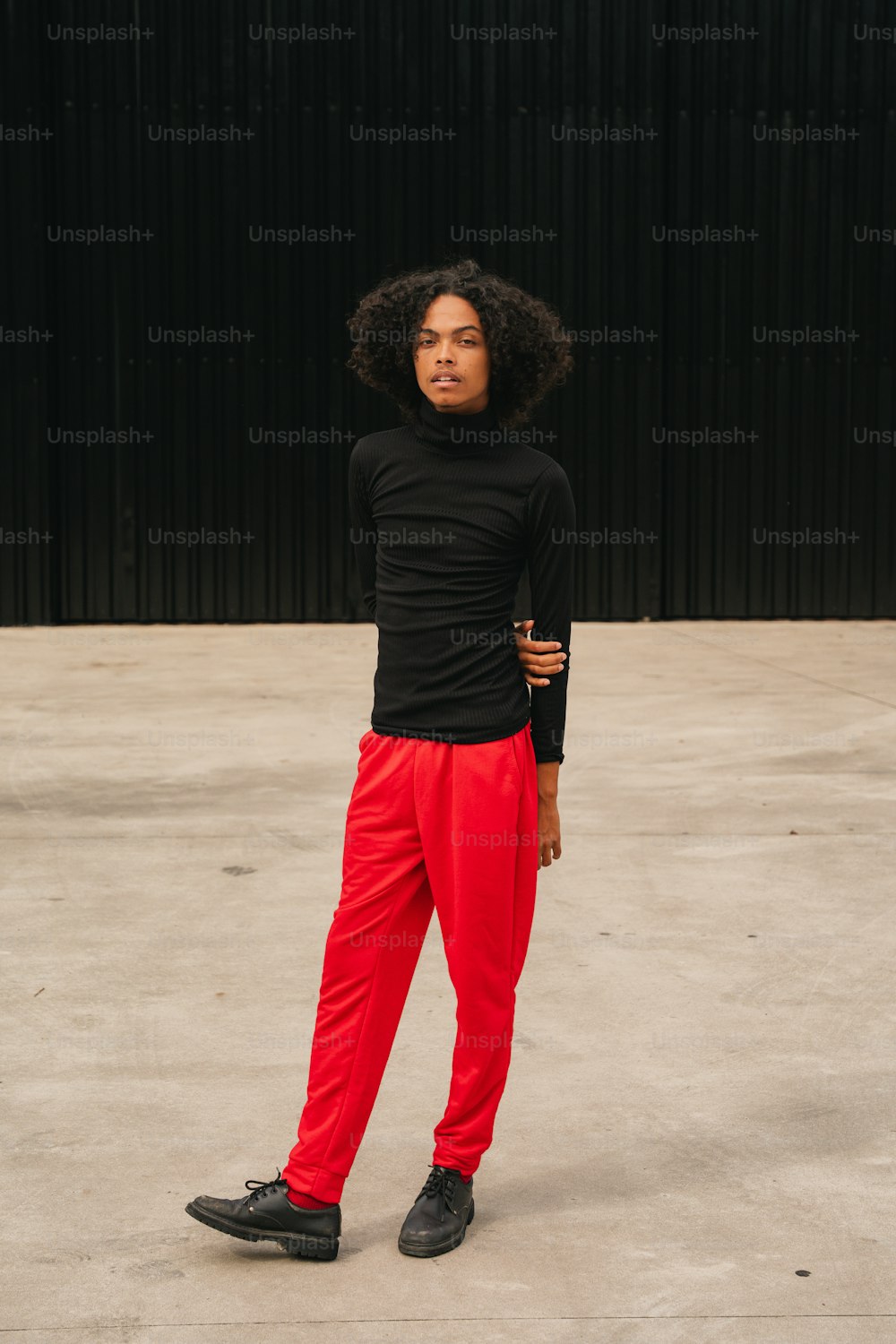 a woman in a black shirt and red pants