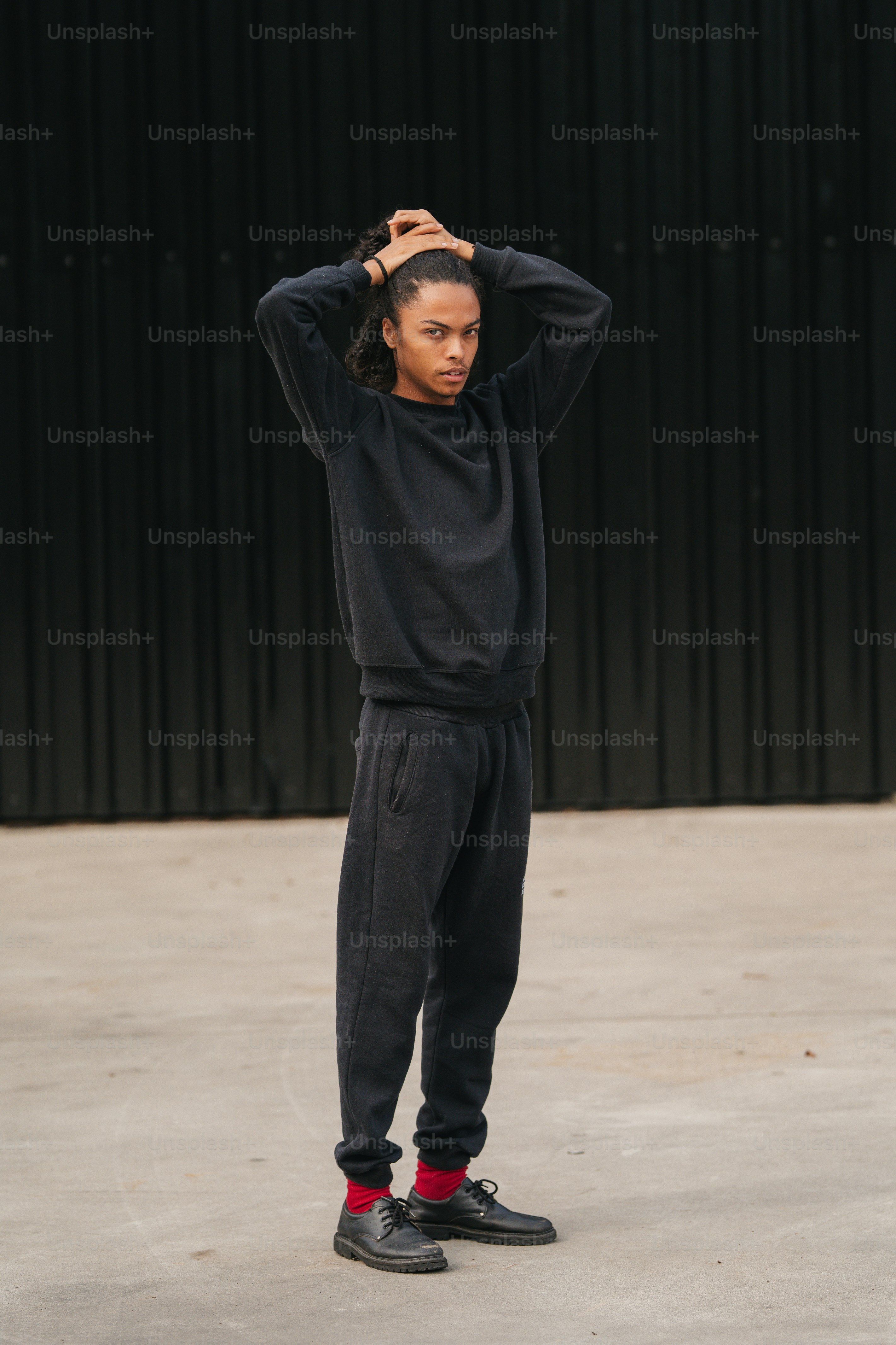 a person standing in front of a black wall