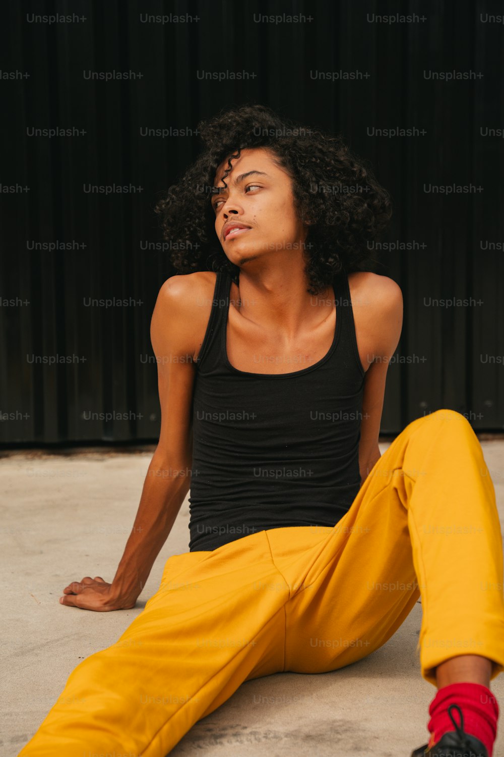 a woman sitting on the ground wearing yellow pants