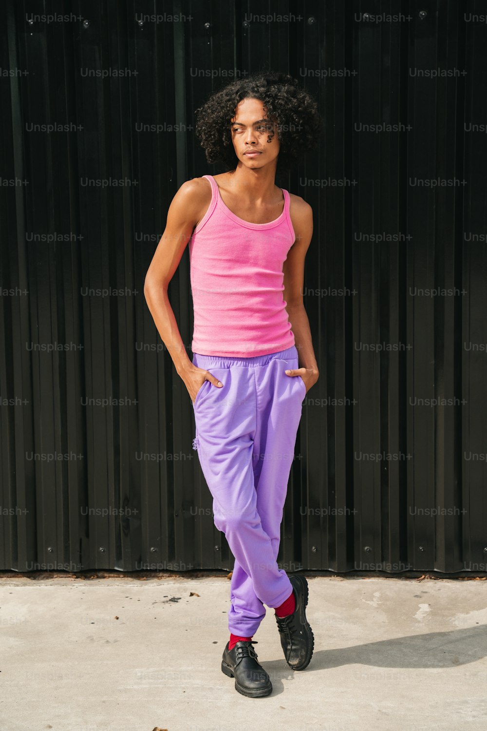 a woman in a pink tank top and purple pants