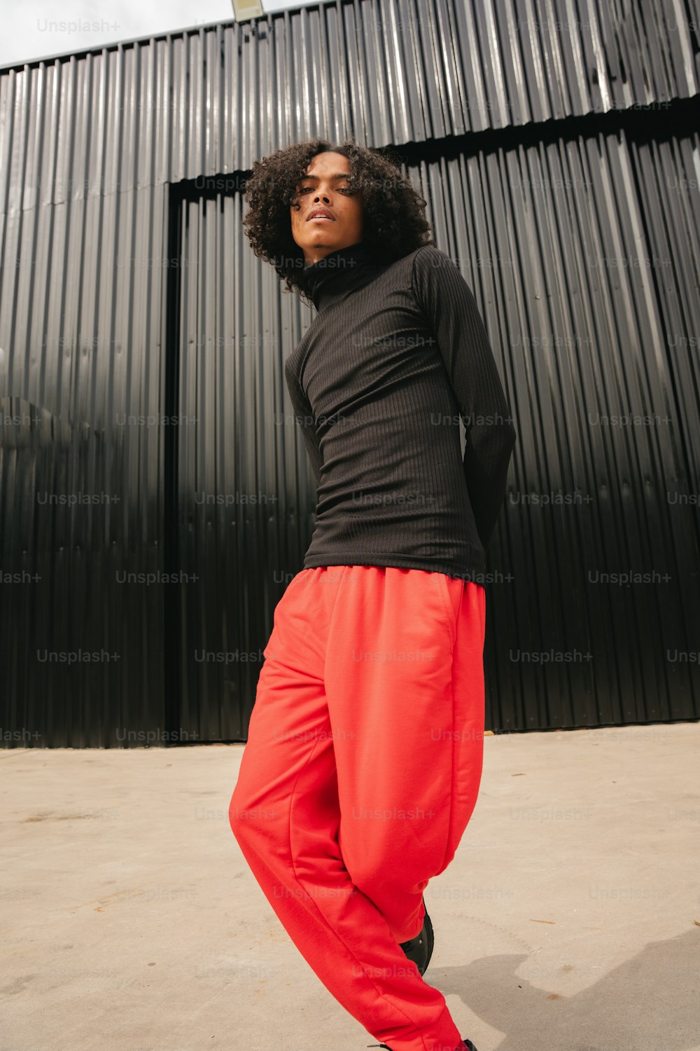 a woman in a black top and red pants