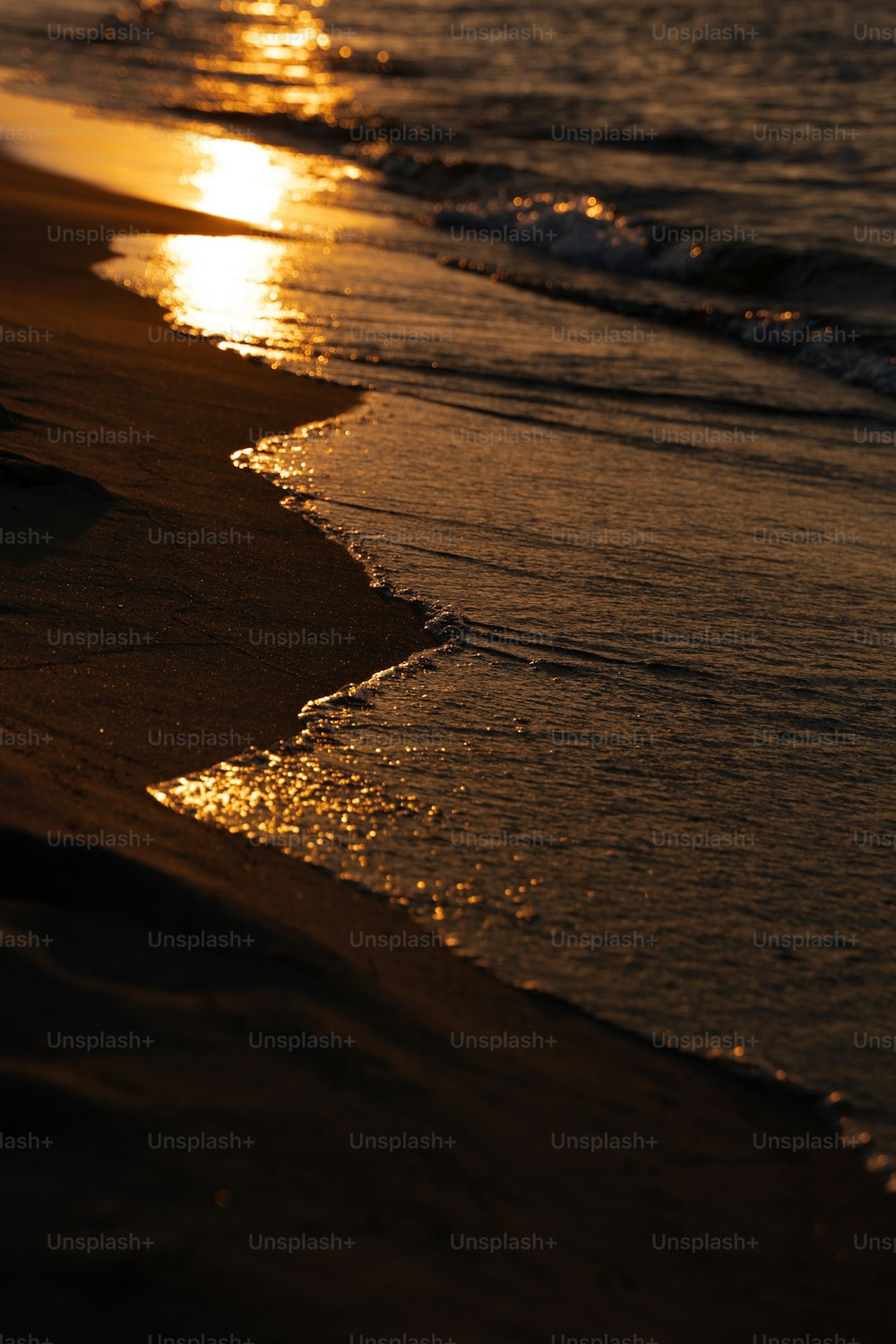 the sun is setting over the water at the beach