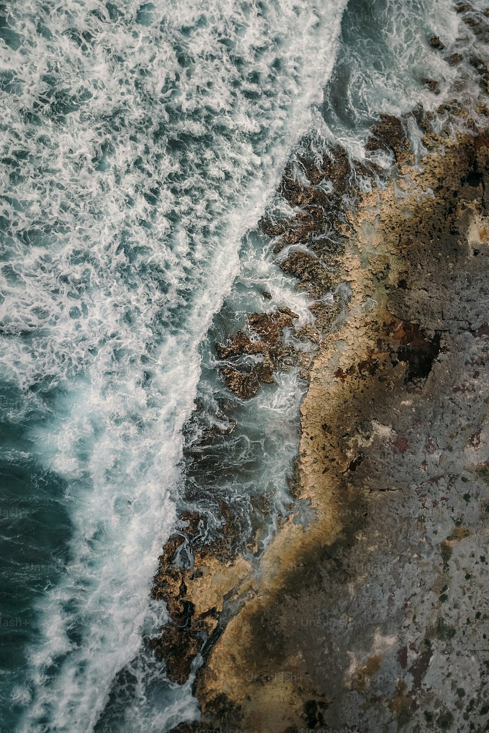 Eine Luftaufnahme des Ozeans mit Wellen, die an das Ufer schlagen