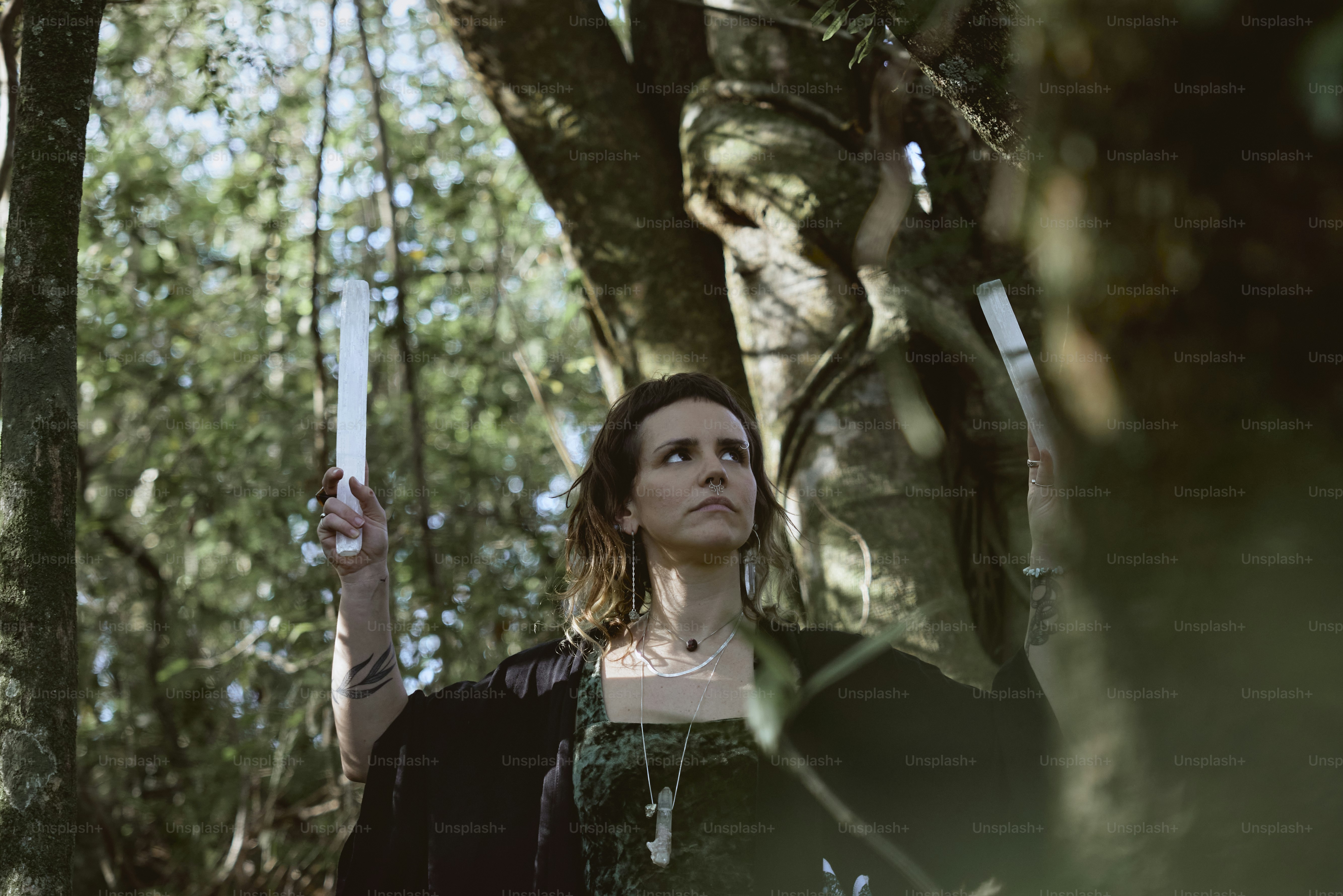 a woman holding a knife in a forest
