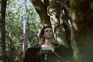 a woman holding a knife in a forest