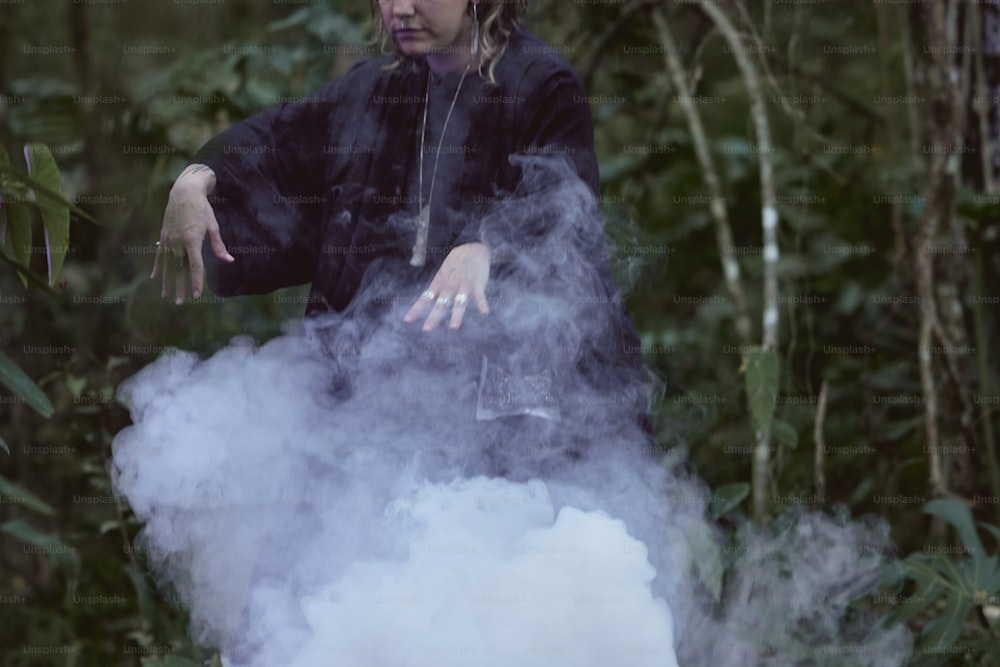 a man in a black jacket standing in smoke