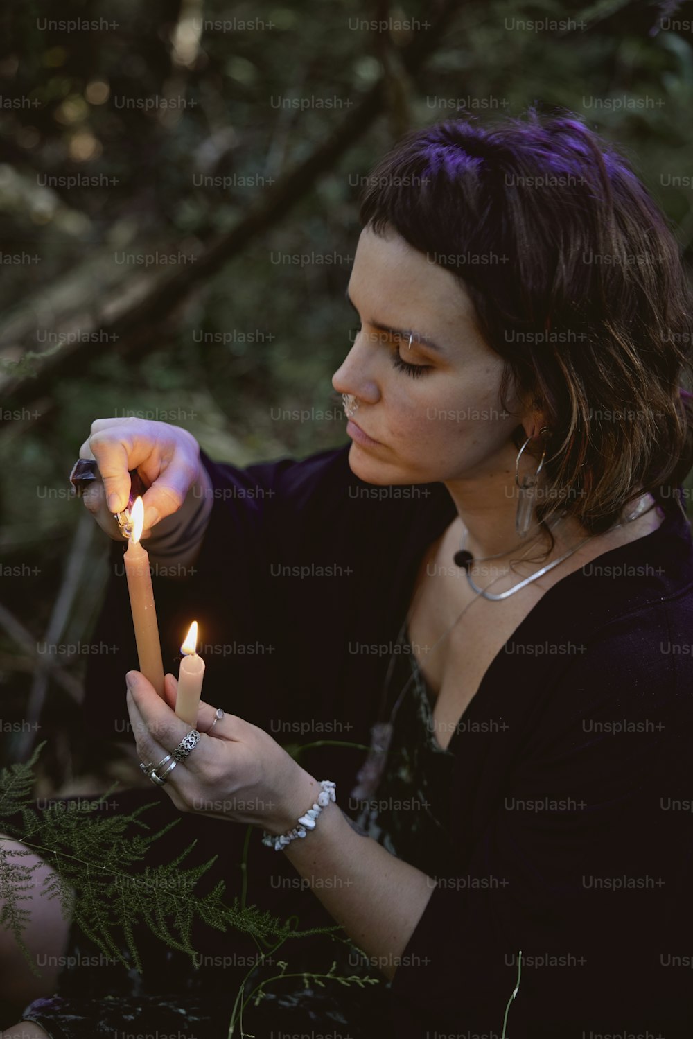 Una mujer sosteniendo una vela encendida en sus manos