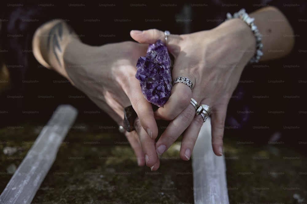 una persona sosteniendo una roca púrpura en sus manos