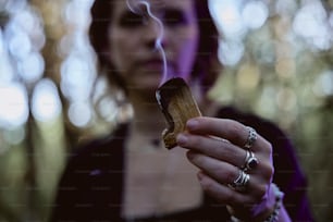 uma mulher segurando um cigarro na mão