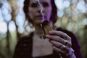 a woman holding a cigarette in her hand