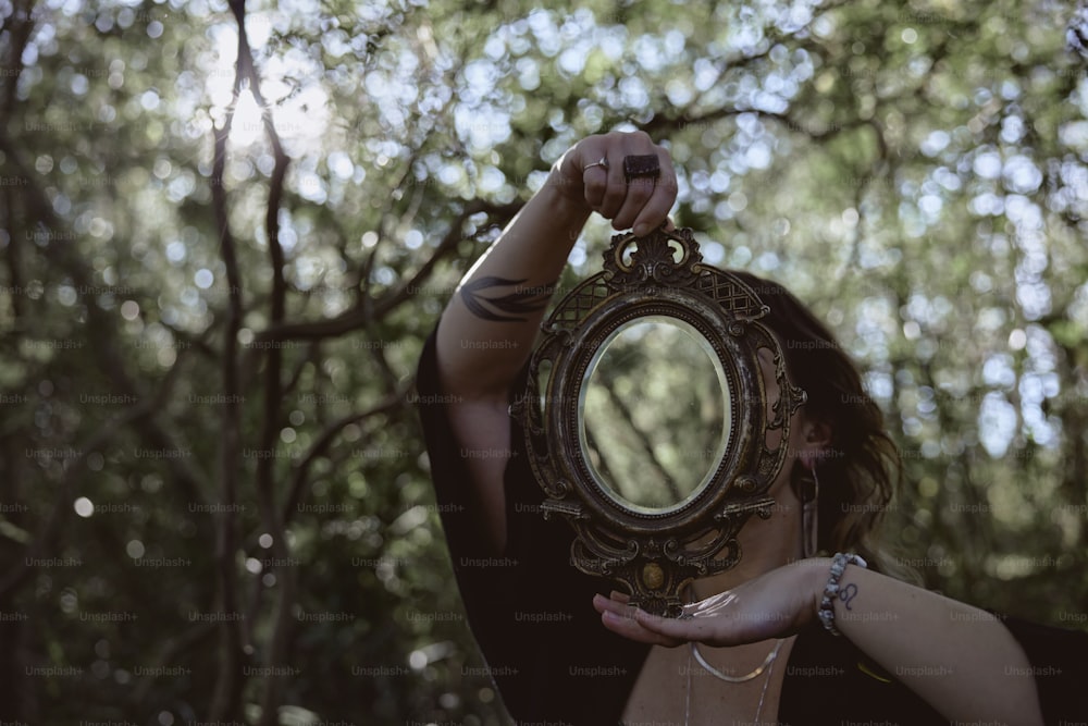 a woman holding a mirror in front of her face