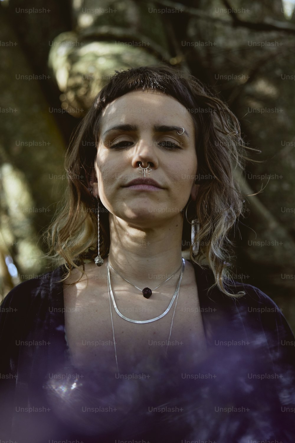 a woman standing in front of a tree