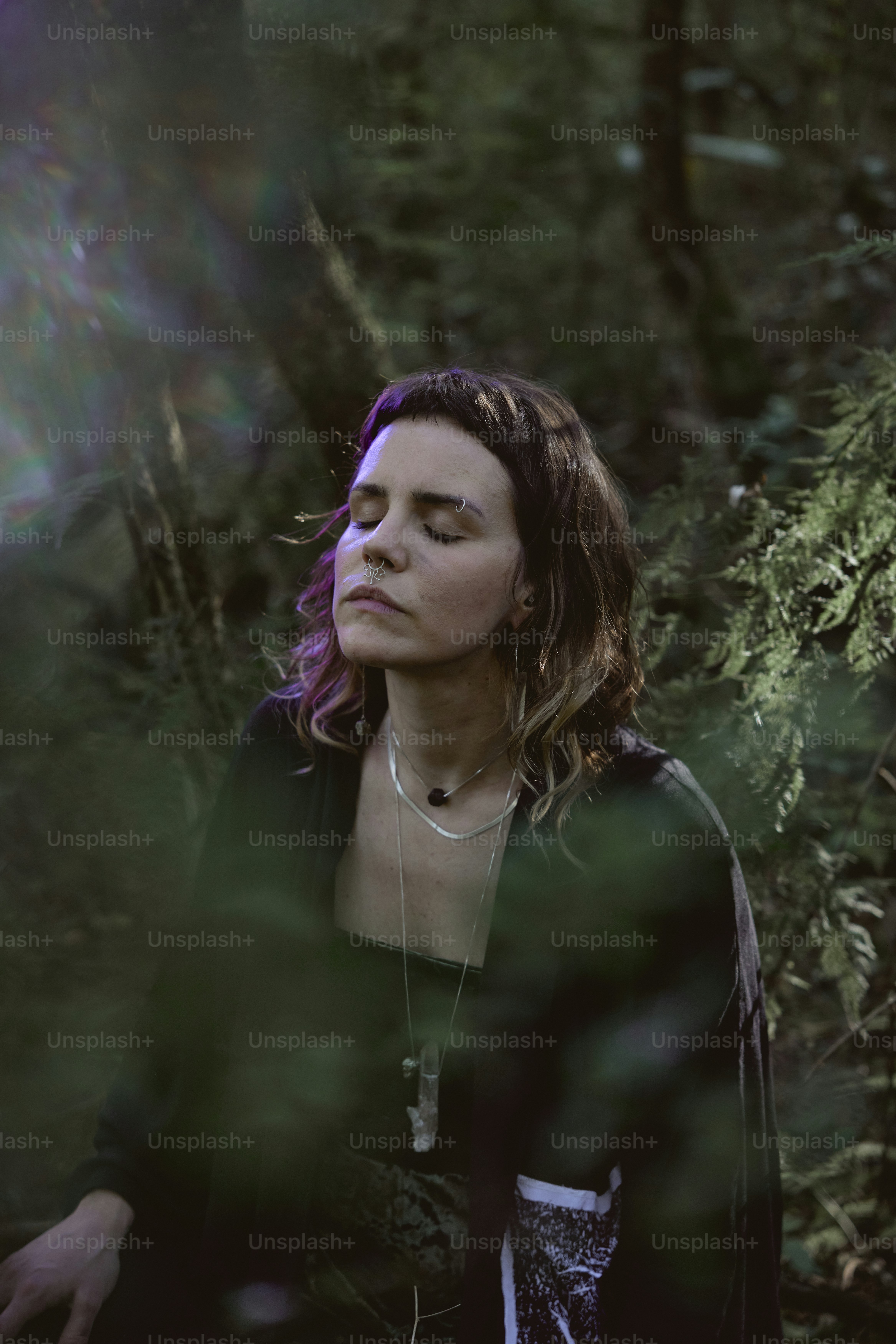 uma mulher em pé no meio de uma floresta