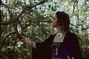 a woman holding a magnifying glass up to a tree