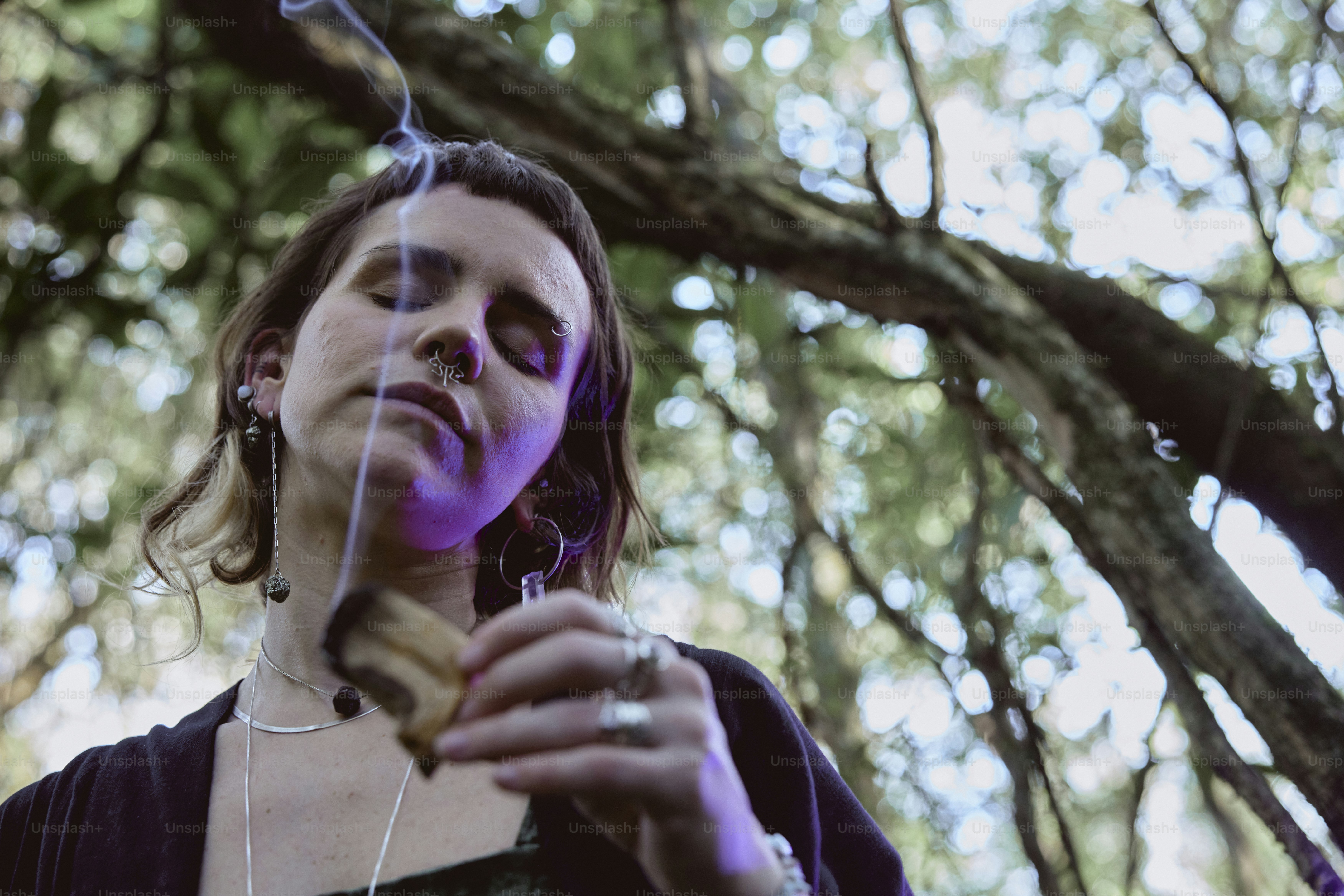 uma mulher em pé em frente a uma árvore segurando um pedaço de comida