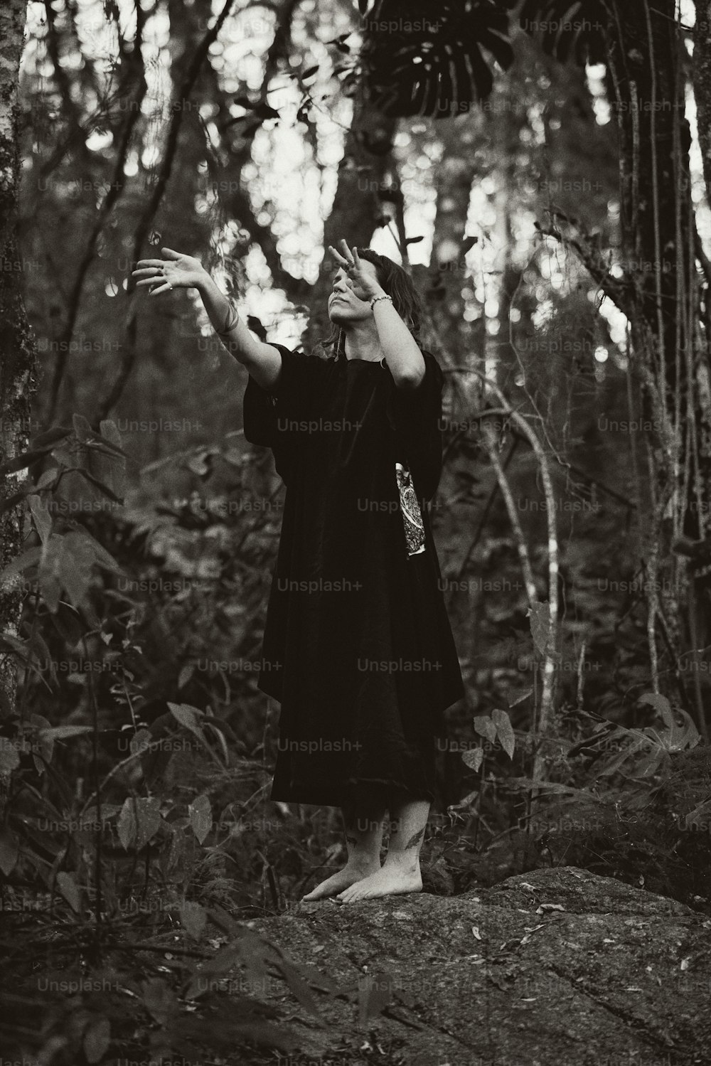 Una donna in piedi su una roccia nel bosco