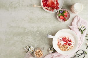 uma tigela de iogurte e uma tigela de morangos sobre uma mesa