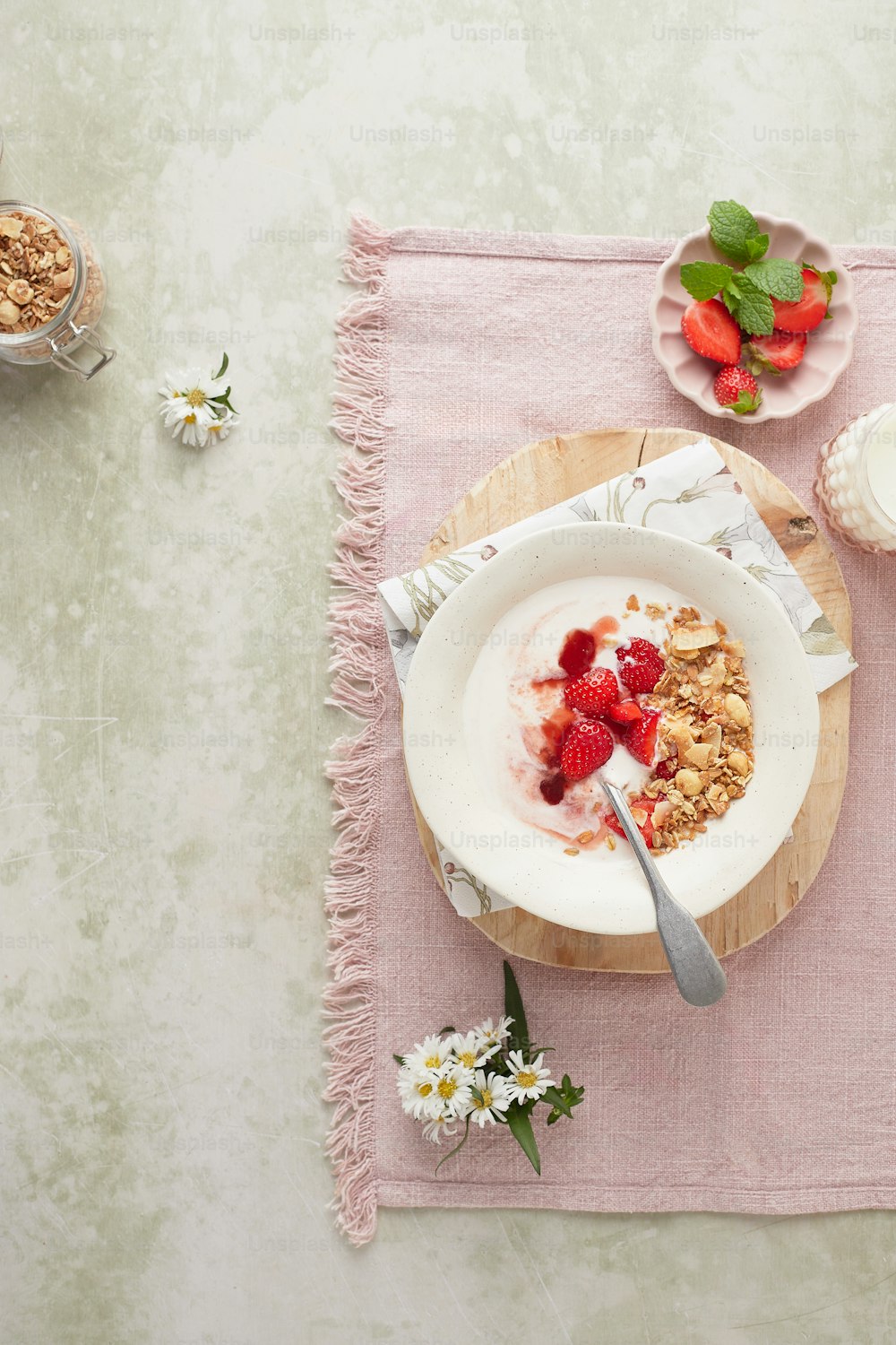un bol de céréales et un bol de fraises sur une table
