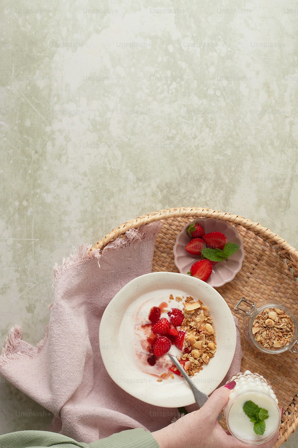 a person eating a bowl of cereal and yogurt