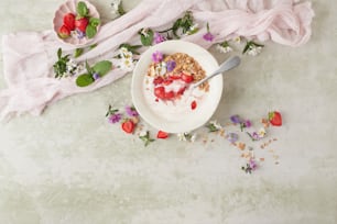 uma tigela de iogurte com morangos e flores