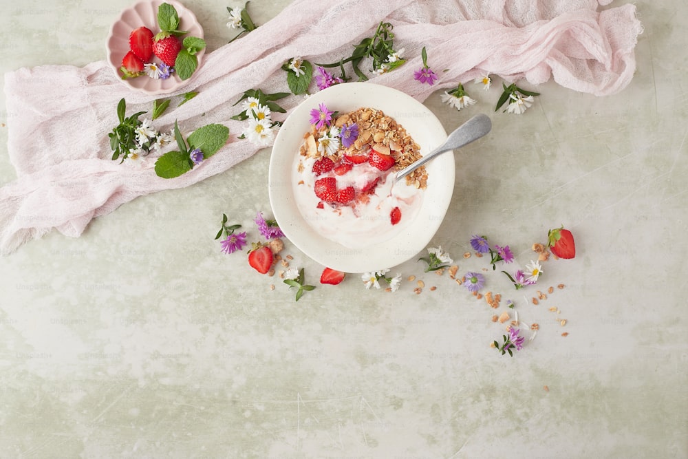 a bowl of yogurt with strawberries and flowers
