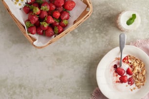 a bowl of strawberries and a bowl of yogurt