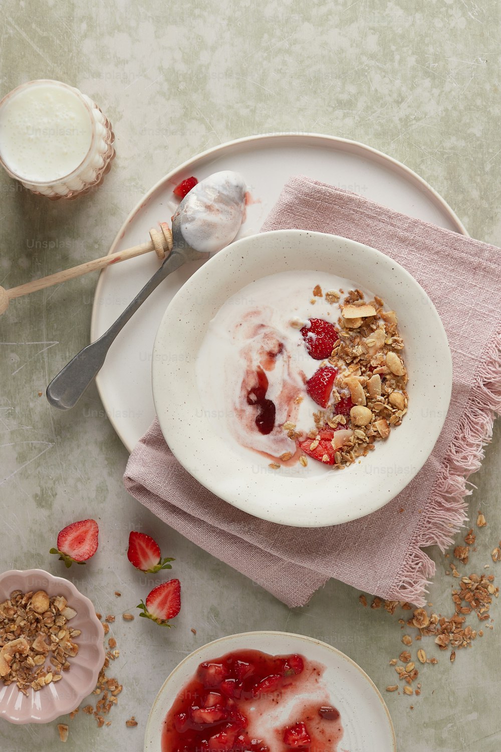 a bowl of yogurt, granola, and strawberries on a plate