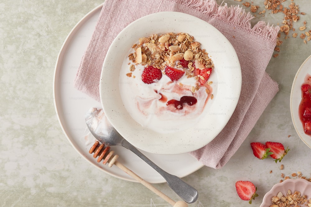 a bowl of yogurt with granola and strawberries