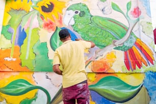 a man painting a mural on the side of a building