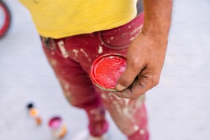 a man is holding a red can in his hand
