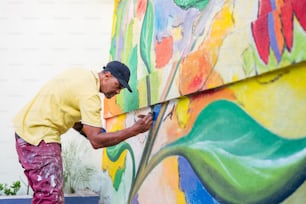 a man painting a wall with colorful paint