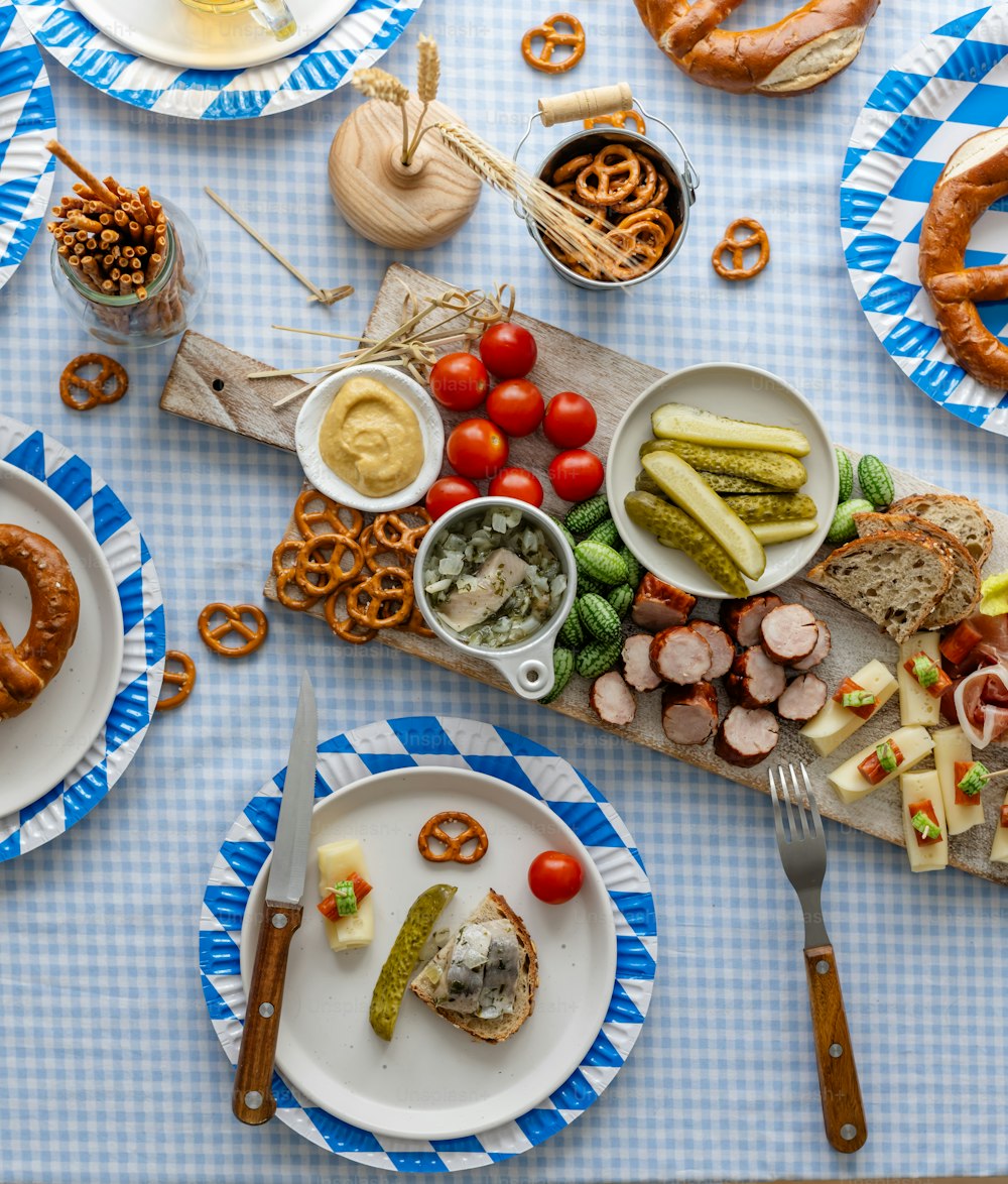 a table topped with plates of food and pretzels