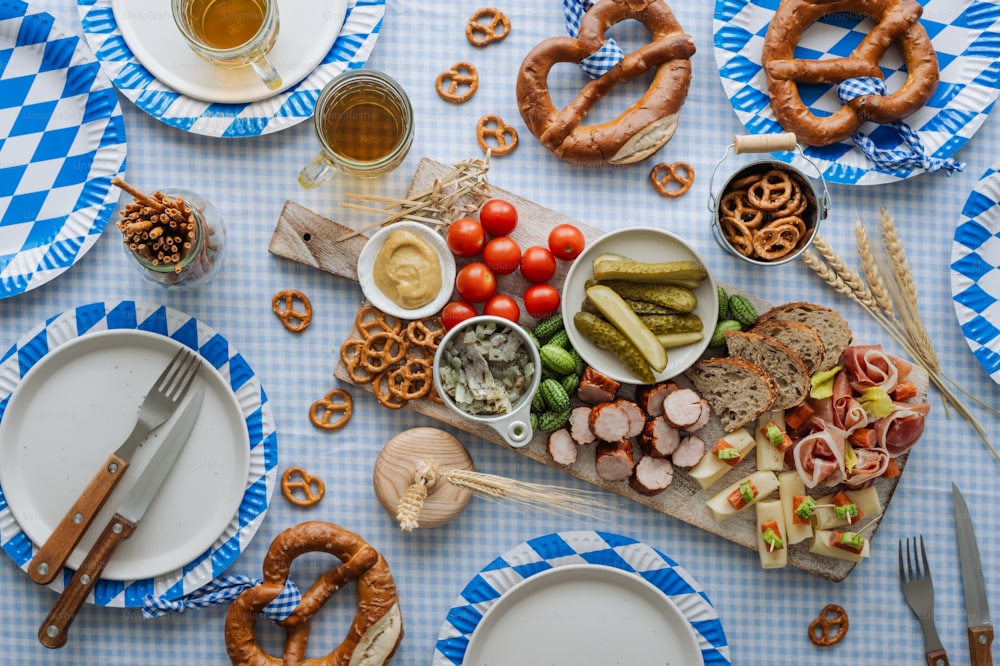 une table garnie d’assiettes de nourriture et de bretzels