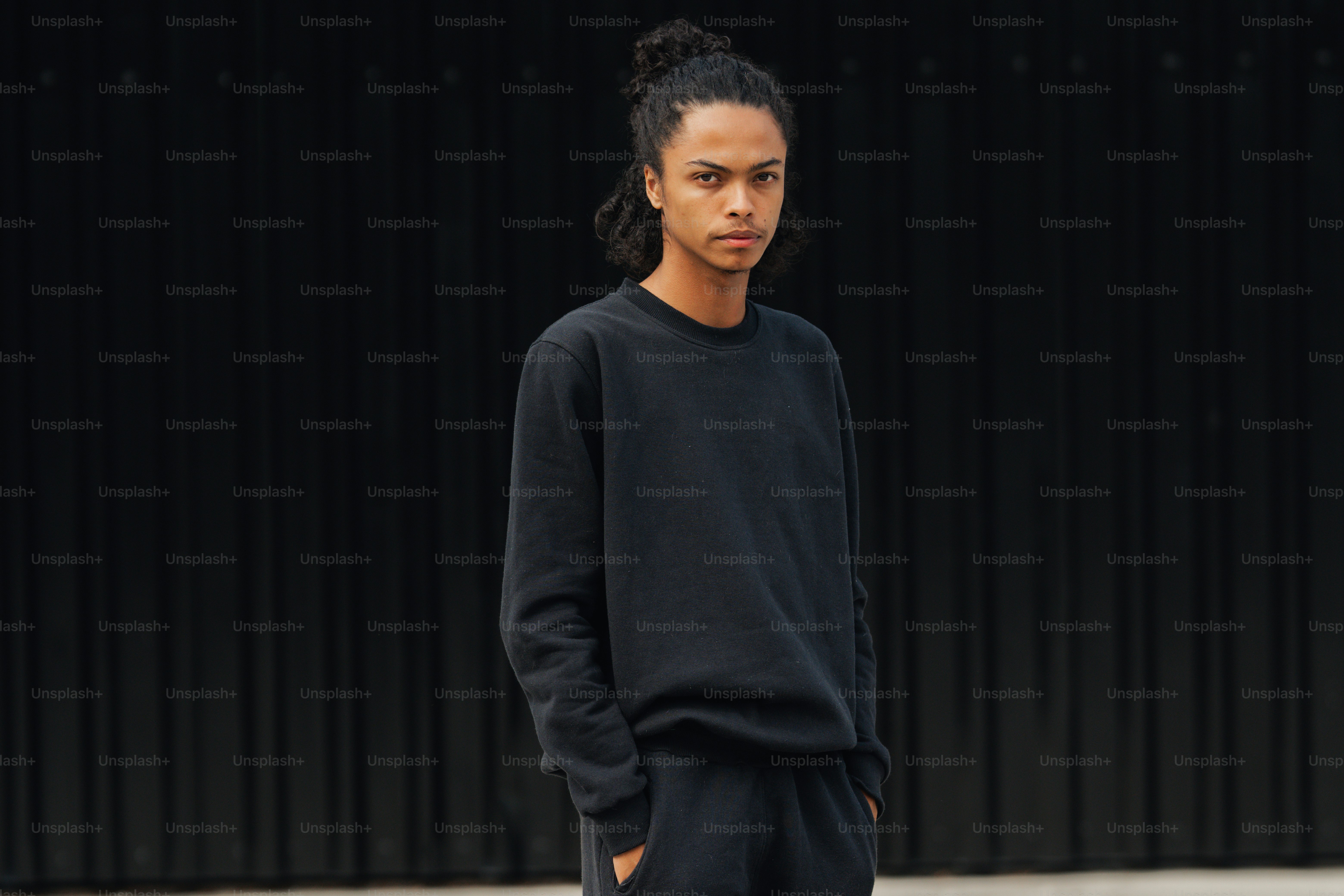 A young man standing in front of a black wall photo – Black t shirt ...