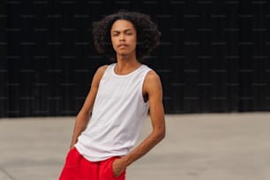 a young man in a white tank top and red shorts