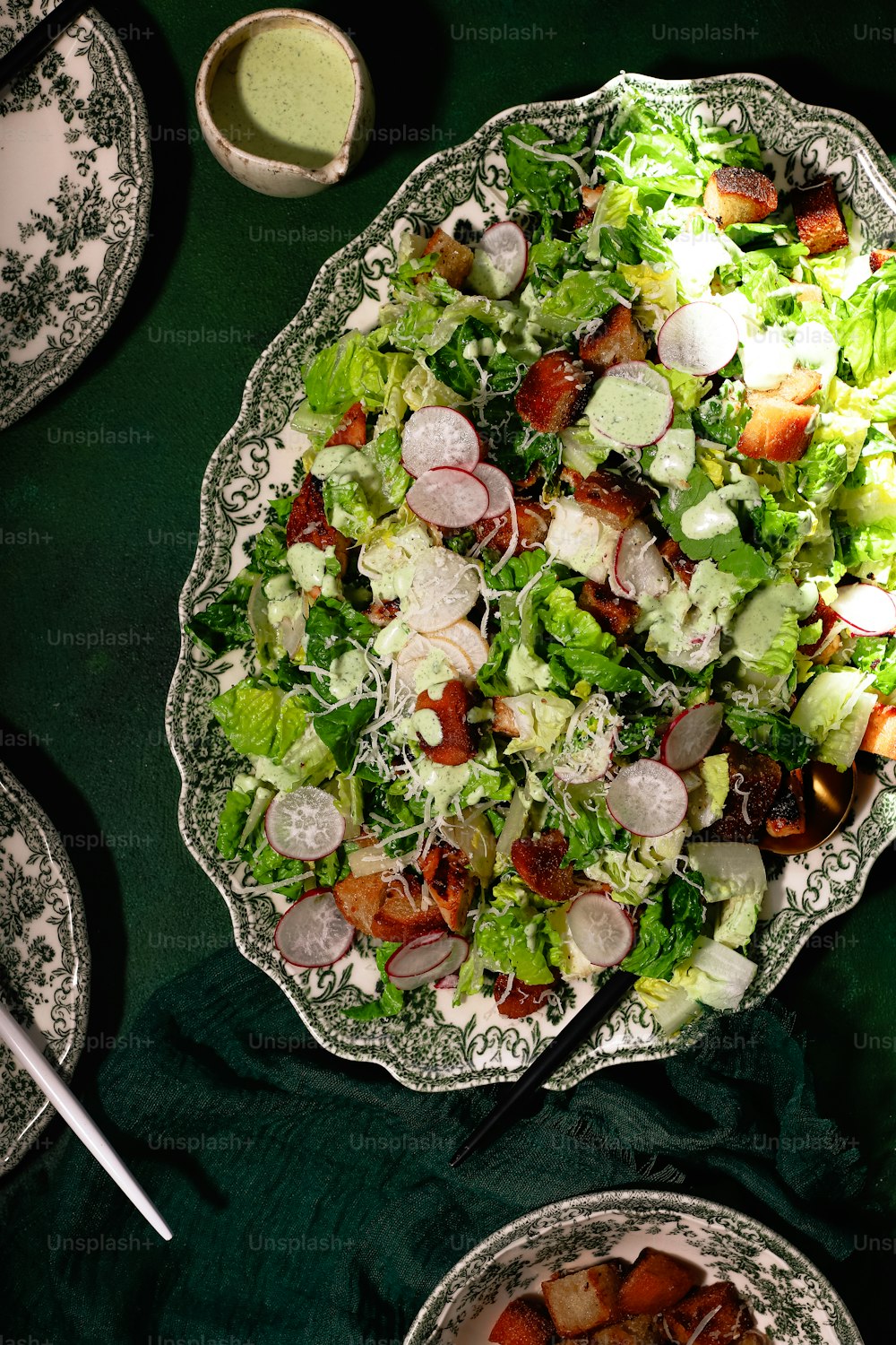 ein Teller Salat und eine Schüssel Dressing auf einem Tisch