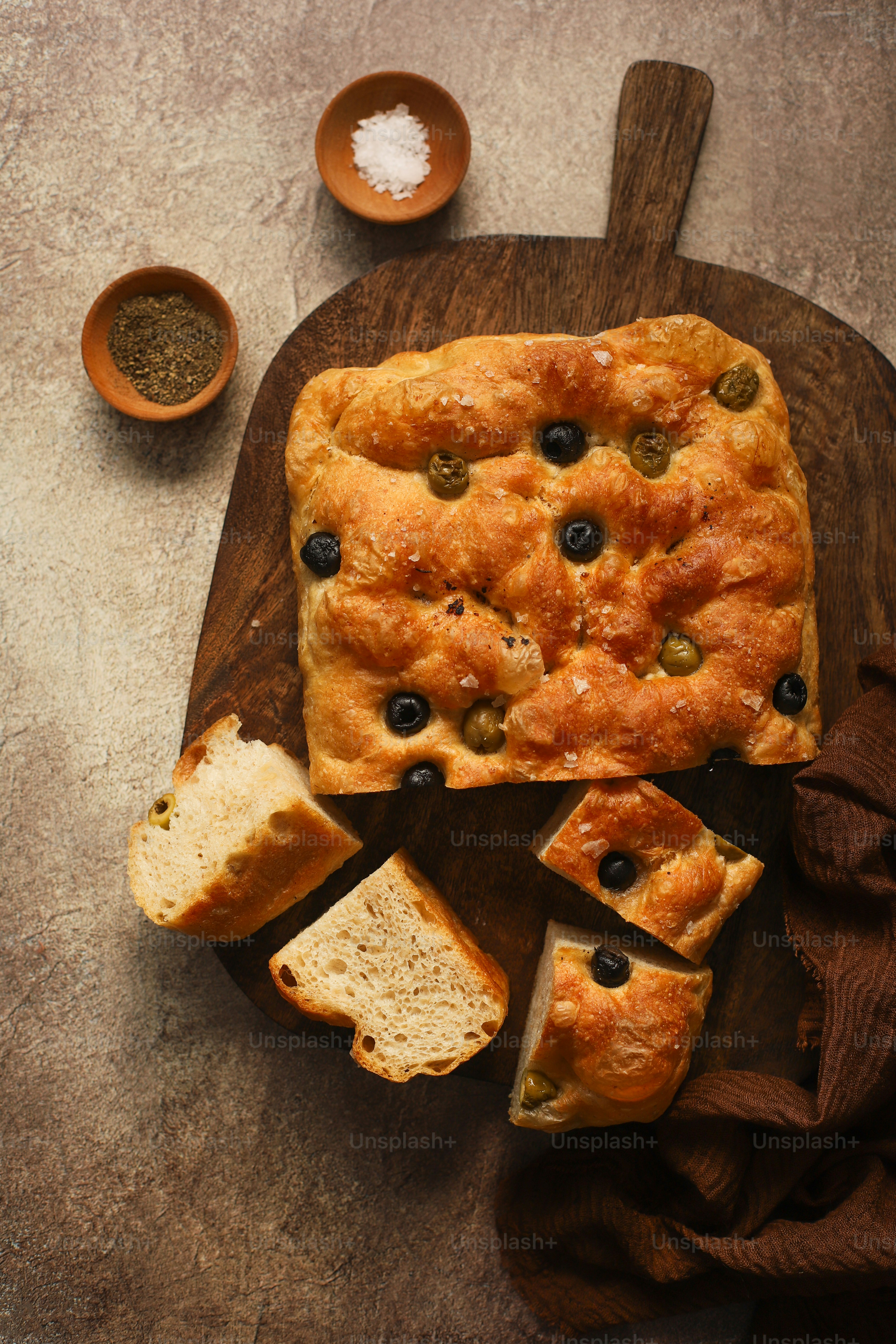 a wooden cutting board topped with a loaf of bread