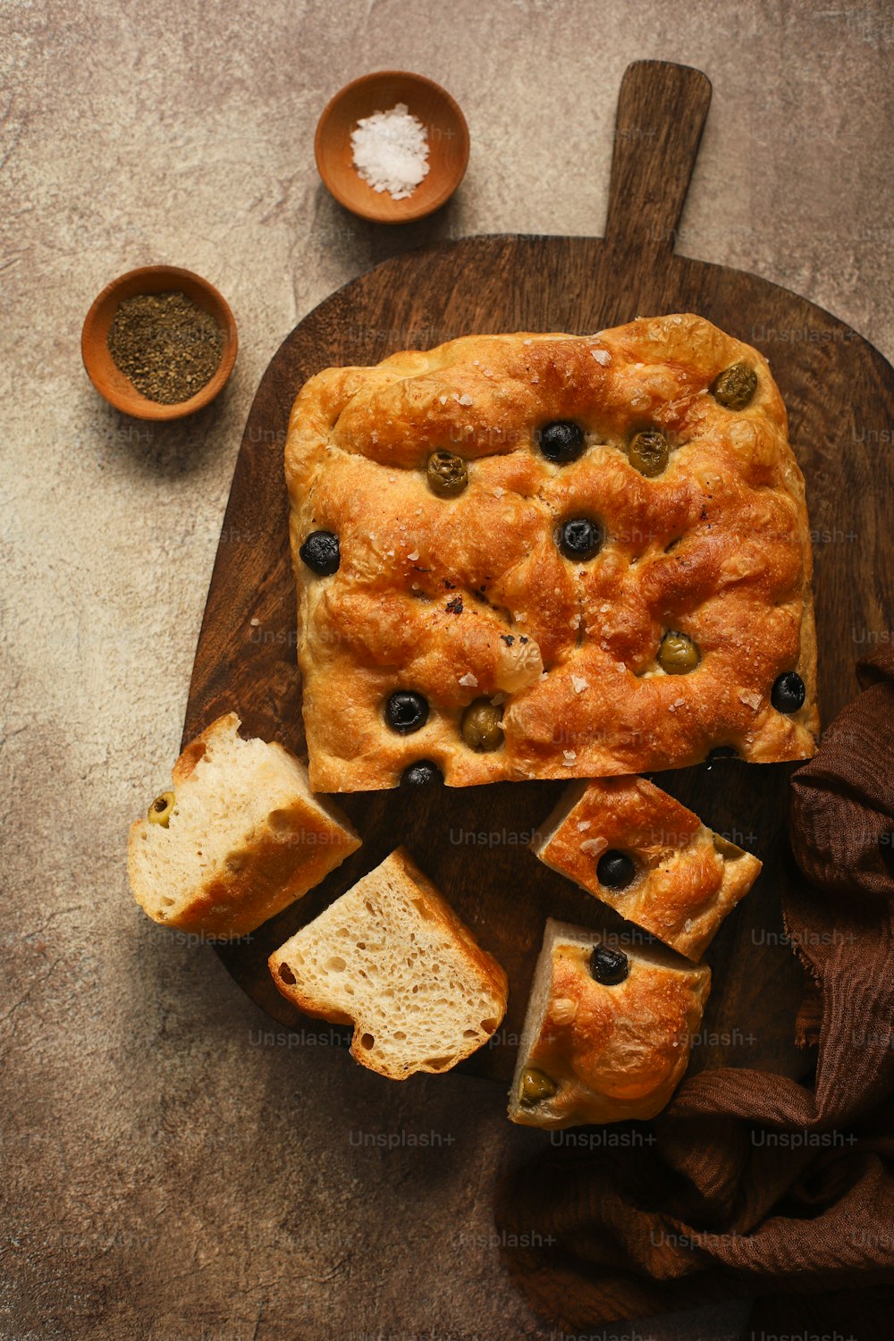 a wooden cutting board topped with a loaf of bread