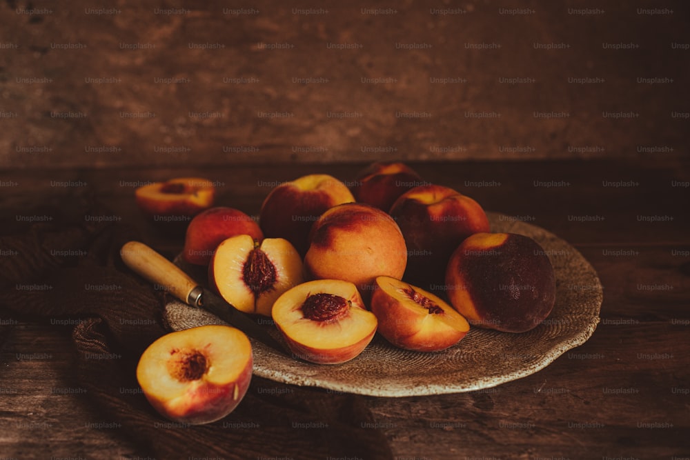 a plate of peaches on a wooden table