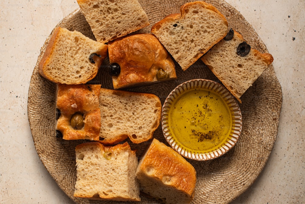 um prato de pão e azeitonas com uma tigela de azeite