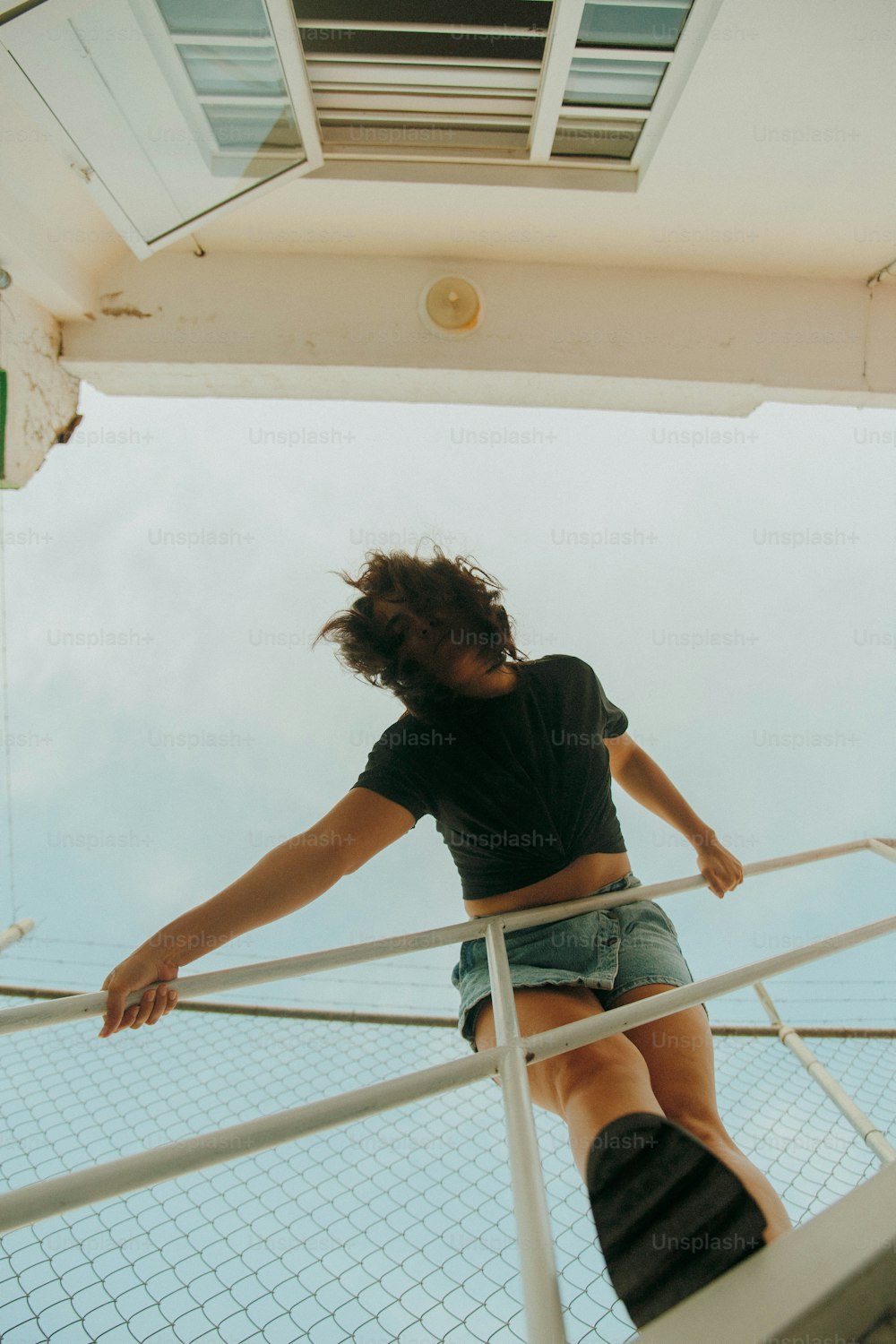 a woman standing on a railing on top of a boat