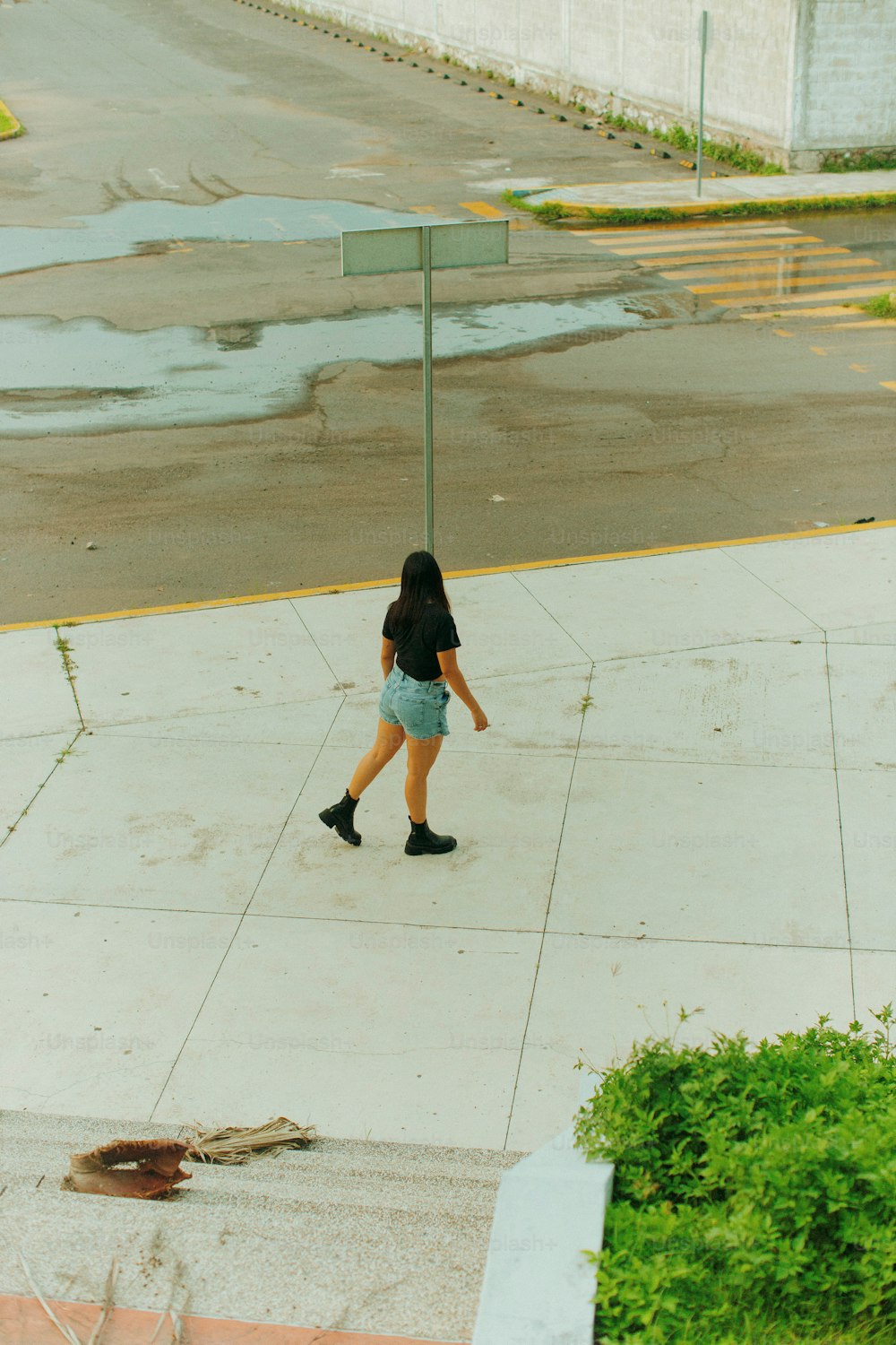 eine Frau, die einen Bürgersteig neben einer Straße entlanggeht
