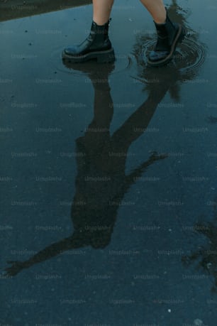 a person standing in a puddle holding an umbrella