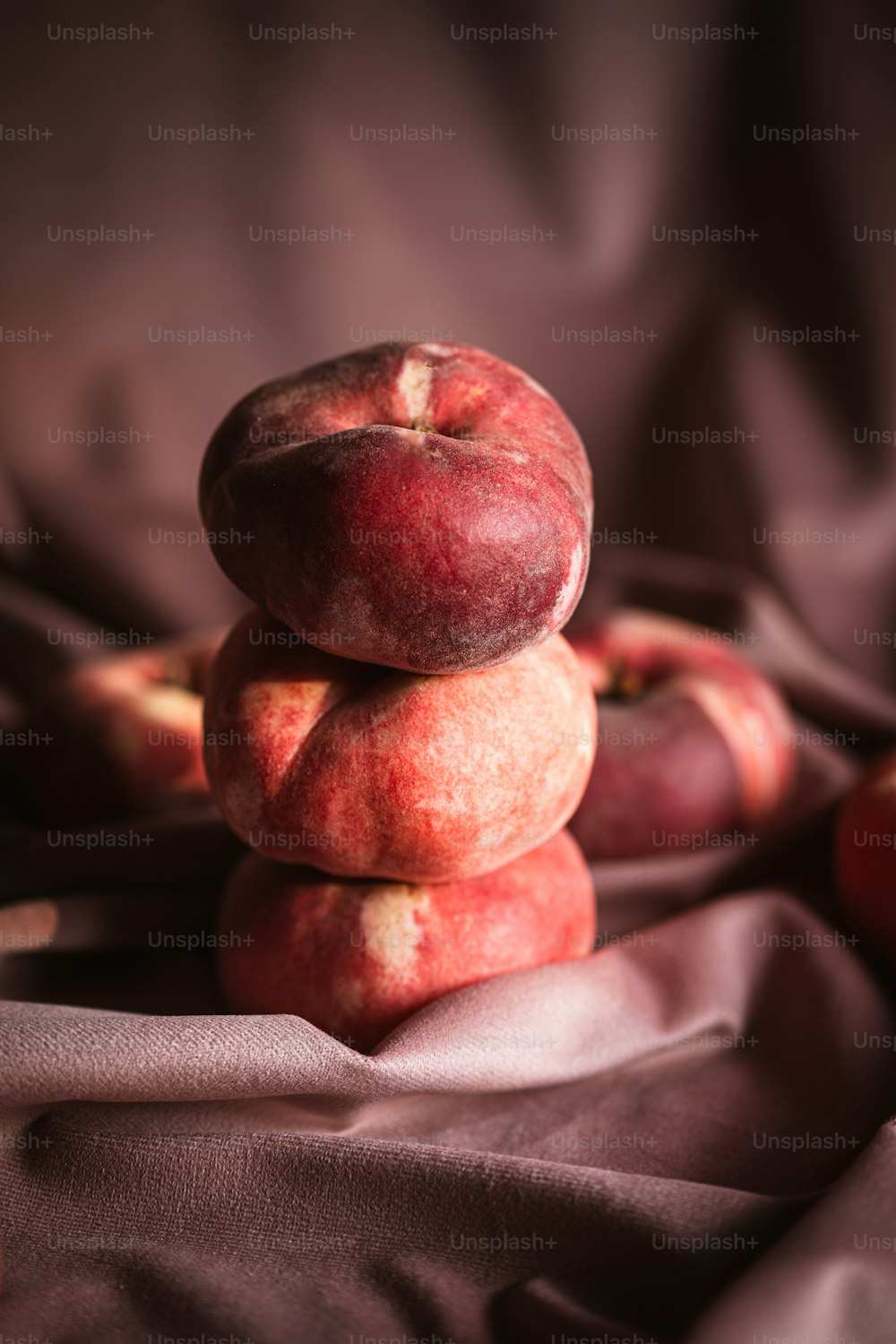 a stack of apples sitting on top of a bed