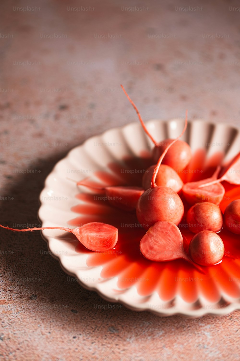 uma tigela branca cheia de frutas vermelhas em cima de uma mesa