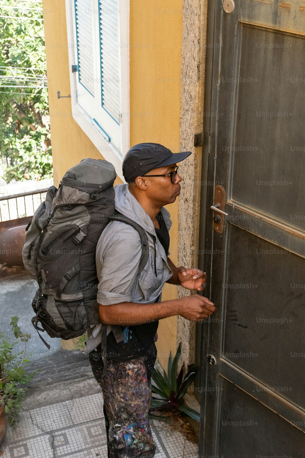 a man with a backpack is standing in front of a door