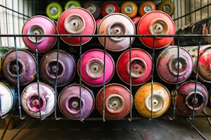 Un estante lleno de latas de spray de diferentes colores