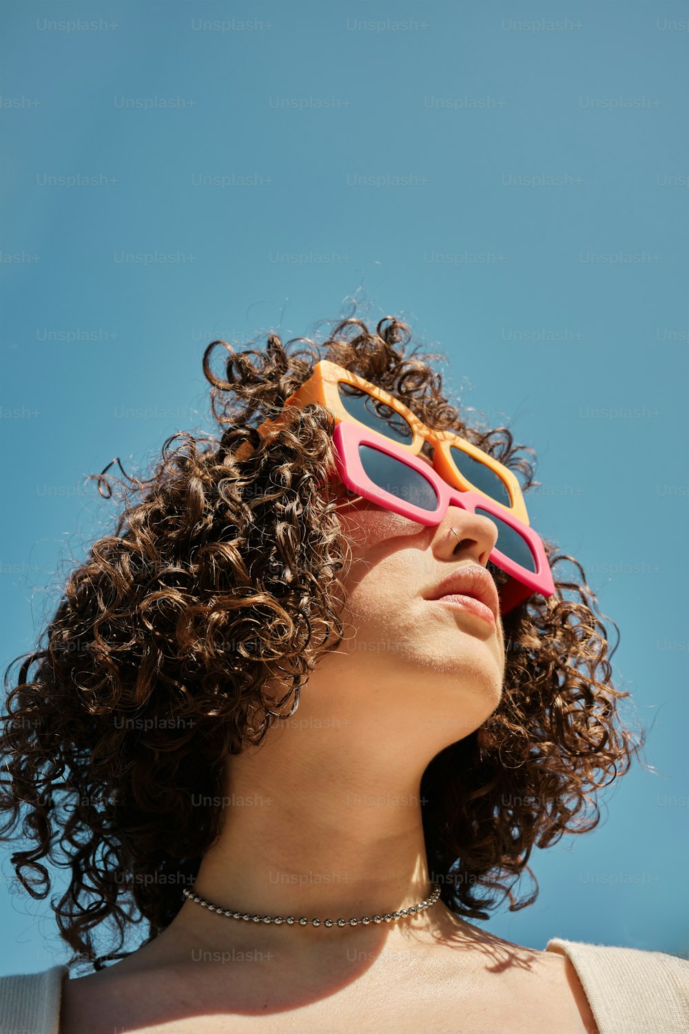 a woman with curly hair wearing sunglasses