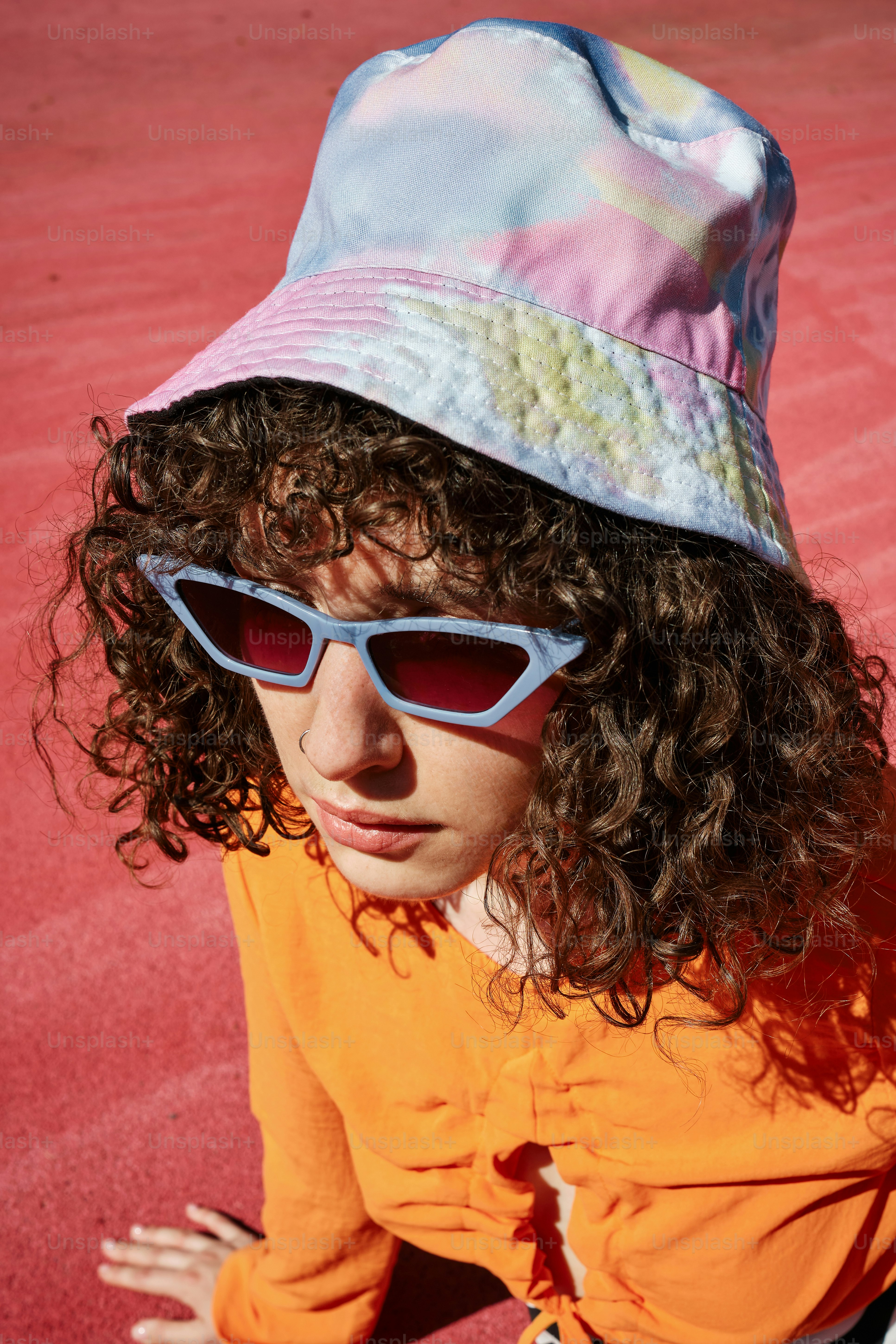 Eine Frau mit Sonnenbrille und Hut auf einem Tennisplatz
