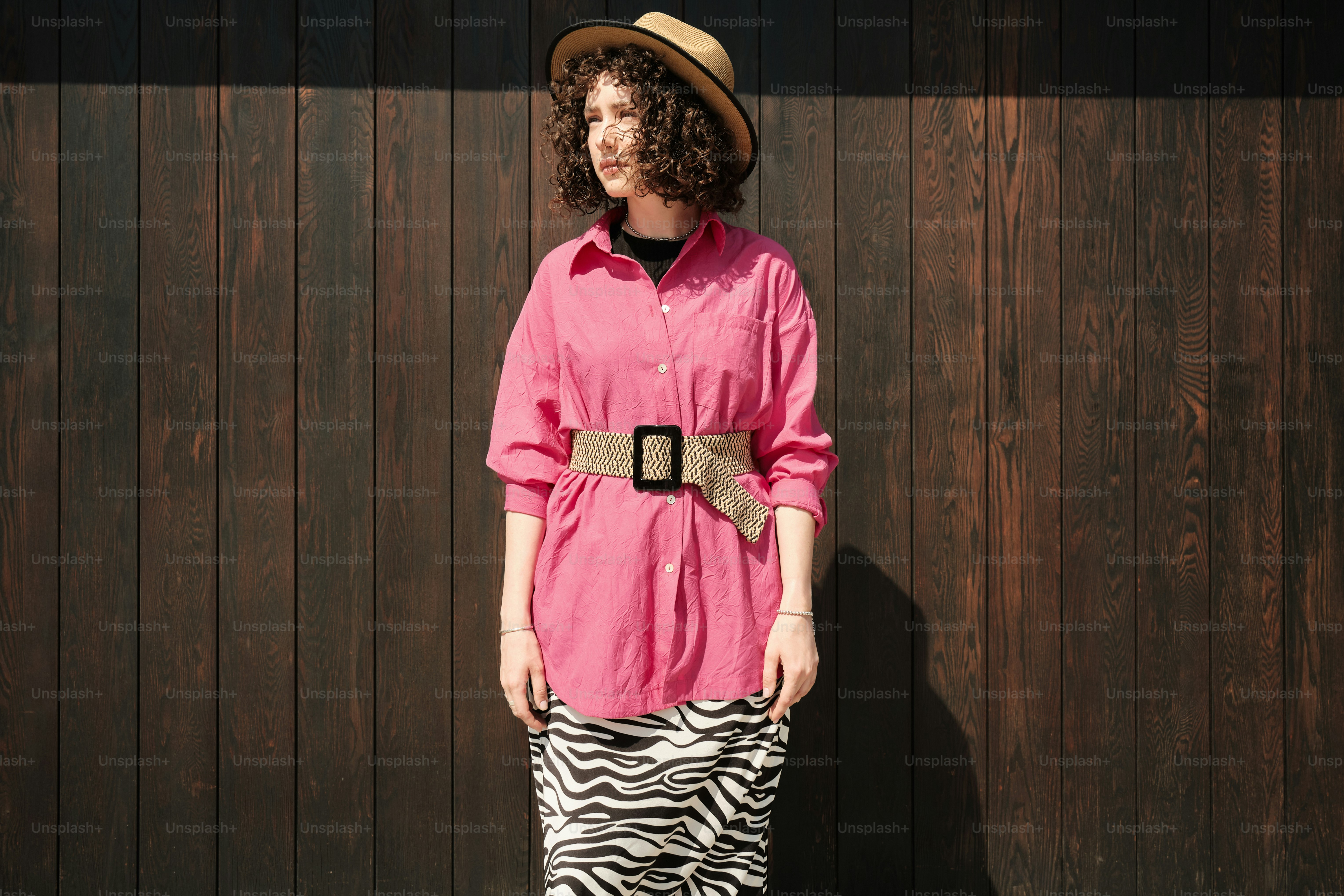 uma mulher em uma camisa rosa e saia com estampa de zebra